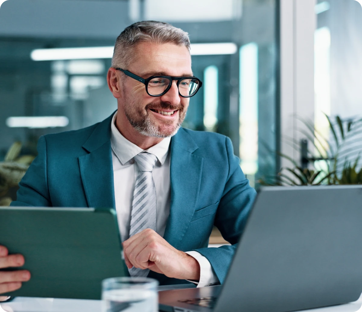 Professional man holding tablet at desk